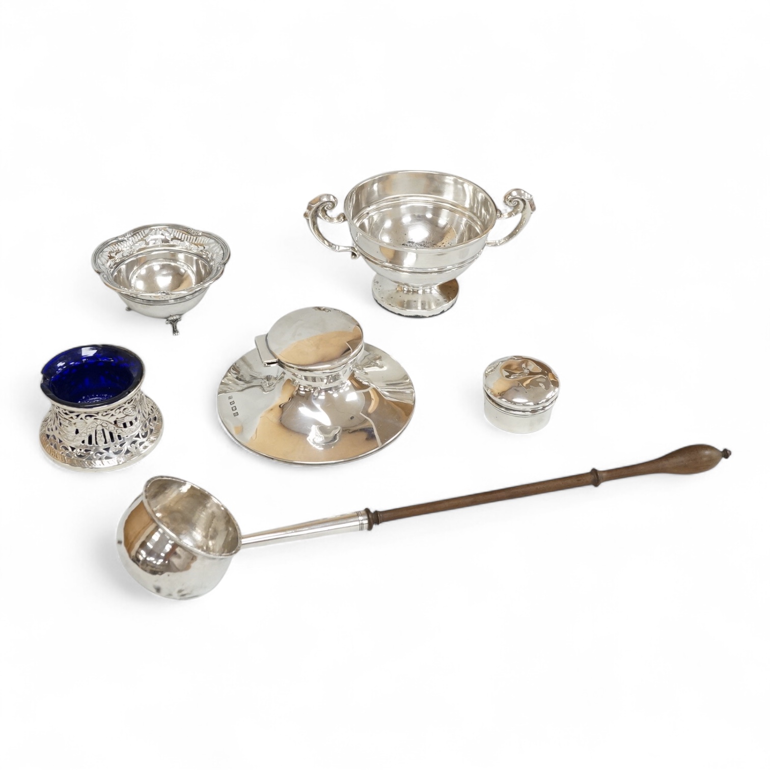 A George V silver mounted capstan inkwell, A & J Zimmerman Ltd, Birmingham, 1913, diameter 11.4cm, together with a small silver bowl, a small silver 'dish ring' salt(a.f.), a silver two handled bowl, a silver pill box an